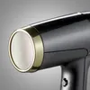 Close-up of the nozzle of a black hairdryer with a gold trim and a textured circular grille. Anteprima dell’immagine prodotto