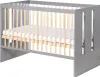 A baby crib with a mattress inside, shown from a side-angle. Náhled obrázku produktu