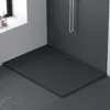 A modern, minimalist bathroom corner featuring a dark grey, extra-flat shower tray with a linear drain. A window with bottles of toiletries is visible on the left. Produktbild-Vorschau