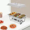 A chafing dish filled with food, along with side dishes of strawberries and what appears to be pork trotters. Podgląd zdjęcia produktu