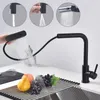 A black kitchen faucet with a pull-down sprayer is shown in use, demonstrating different spray modes and rinsing fruit. Produktbild-Vorschau