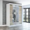 A modern sliding door wardrobe with mirrored panels and wood-effect accents, set against a grey wall and wooden floor in a room with large windows. Produktbild-Vorschau