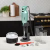 A Bamix immersion blender and its accessories are displayed on a countertop in a kitchen setting. Náhled obrázku produktu