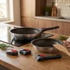 Pans and detachable handles are arranged on a wooden kitchen counter. Produktbild-Vorschau
