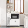 A white kitchen sideboard with a microwave, coffee machine, and other kitchen appliances on top, set against a white wall and a window with blinds. Anteprima dell’immagine prodotto