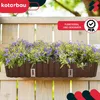 A brown planter box filled with purple flowers is mounted on a wooden fence. Náhľad obrázku produktu