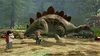 Two Lego characters stand in a forest clearing facing a large Lego dinosaur. Náhled obrázku produktu
