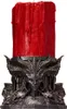 A red candle in a decorative, dark-colored holder with a demonic or gothic design. Produktbild-Vorschau