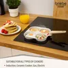 A multi-compartment frying pan with food items on a stovetop, next to a stack of pancakes and a glass of orange juice. Náhľad obrázku produktu