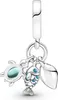 A silver charm with three dangling pendants: a turtle with a blue gem, a fish with blue scales, and a shell. Anteprima dell’immagine prodotto