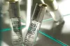 Three small glass perfume oil bottles with silver caps are arranged diagonally on a reflective surface, with one bottle in the foreground and two slightly behind and to the left, all angled towards the viewer. Anteprima dell’immagine prodotto