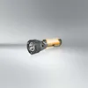 A black and gray flashlight with an orange illuminated interior, set against a light gray and white gradient background. Produktbild-Vorschau
