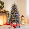 A decorated Christmas tree with presents underneath, next to a fireplace and a lantern. Náhled obrázku produktu