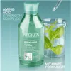 A bottle of Redken Amino-Mint shampoo is shown next to a beaker with mint leaves, suggesting a natural ingredient focus. Produktbild-Vorschau