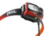 Close-up shot of a red Petzl headlamp with a black and orange strap, connected to a charging cable. Produktbild-Vorschau