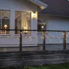 A house deck at dusk, decorated with icicle lights along the railing. Podgląd zdjęcia produktu