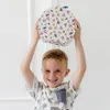 A young boy is holding a round, patterned box above his head. Produktbild-Vorschau