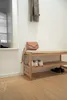 A hallway bench with shoes and a handbag, with a scarf hanging on the wall. Náhled obrázku produktu