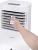 A hand holding a remote control in front of a Honeywell air cooler. Produktbild-Vorschau