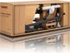 The image shows an elliptical trainer packed inside its cardboard box, ready for shipping or assembly. Podgląd zdjęcia produktu