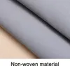 A close-up view of a grey non-woven material, folded and slightly angled, resting on a light-colored wooden surface. Produktbild-Vorschau