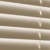 A close-up view of cream-colored horizontal blinds with visible pull cords. Produktbild-Vorschau