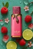A pink perfume bottle with a snake wrapped around it, surrounded by raspberries, lime slices, flowers, and ice cubes on a teal background. Voir les images du produit