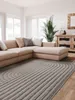 A living room with a sectional sofa, a large rug, and a wooden cabinet. Anteprima dell’immagine prodotto