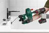 A person is using a drain snake with a drill to clear a clog in a sink. Produktbild-Vorschau