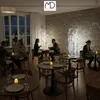 A restaurant interior with people dining at tables, decorated with string lights. Podgląd zdjęcia produktu