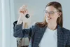 A woman is holding up a key fob. Podgląd zdjęcia produktu