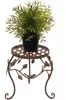 A potted plant sits on a decorative metal stand. Produktbild-Vorschau