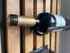 A close-up shot of a wine bottle on a wooden wine rack. Produktbild-Vorschau