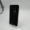 A black smartphone is displayed on a clear plastic stand against a white background. Náhľad obrázku produktu
