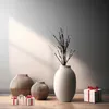 A still life arrangement of decorative vases and gift boxes on a wooden floor, with a wall in the background. Anteprima dell’immagine prodotto