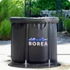 An inflatable ice bath tub is shown outdoors in a garden setting. Produktbild-Vorschau