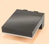 A black outdoor solar light with a white accent strip sits on a light orange background. Produktbild-Vorschau