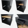 Collage of four close-up shots of a black grill fire pit stand, showing its interior shelves and a drawer. Anteprima dell’immagine prodotto
