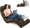A woman is sitting on a brown floor chair and using a laptop. Náhľad obrázku produktu