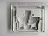 A white plastic toilet flush plate with internal mechanisms is shown from a top-down perspective, with a ruler placed along the top edge. Anteprima dell’immagine prodotto