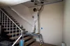 A person is painting a wall while standing on a work platform next to a staircase. Anteprima dell’immagine prodotto