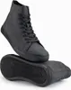A pair of black high-top sneakers shown from a slightly elevated angle, with one shoe standing and the other lying on its sole. Anteprima dell’immagine prodotto