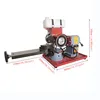A red and gray sharpening machine with a white water tank on top, set against a white background. Dimensions are indicated with text overlays. Náhled obrázku produktu