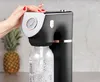 A hand is shown operating a black and rose gold soda maker with a gauge, with a pineapple in the background. Náhled obrázku produktu