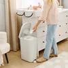 A person is using a diaper pail next to a changing table with a baby on it. Produktbild-Vorschau