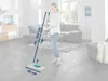 A woman is using a mop in a living room. Produktbild-Vorschau