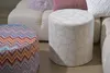 Two ottomans are placed in front of a sectional sofa with decorative pillows. Produktbild-Vorschau