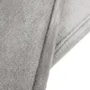 A close-up view of a folded gray blanket, showing its soft texture and stitched edge. Produktbild-Vorschau