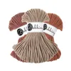 Three skeins of macrame cord in different earthy tones, arranged in a fan shape against a white background. Podgląd zdjęcia produktu