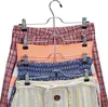 A multi-tiered clothes hanger holding several skirts or shorts. Produktbild-Vorschau